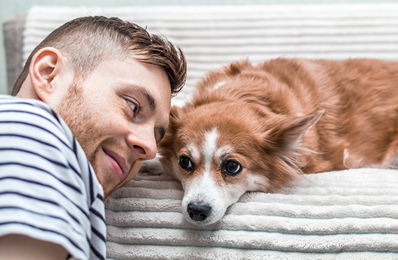 male on sofa with small dog