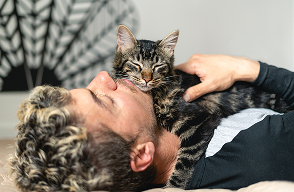 cat cuddles with male owner