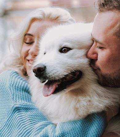 Happy white dog with couple